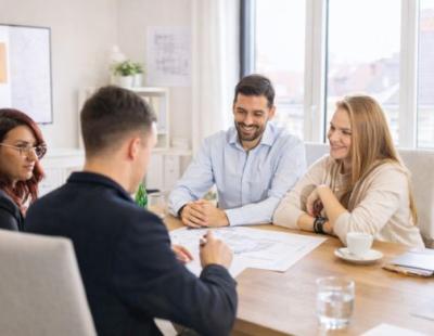 4 PERSONNES A TABLE EN TRAIN DE DISCUTER AUTOUR D UN PLAN